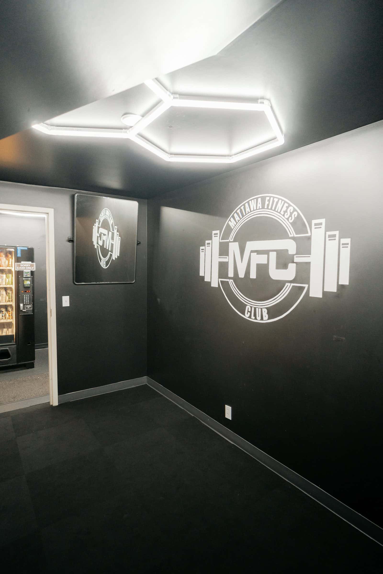 The posing room: black walls, hexagon ceiling lights and the MFC logo